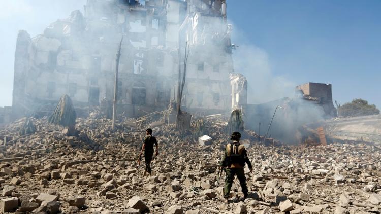 Des rebelles Houthis inspectent les dégâts, le 5 décembre 2017, après une frappe aérienne attribuée à la coalition militaire menée par Ryad contre le palais présidentiel à Sanaa,  [Mohammed HUWAIS / AFP/Archives]