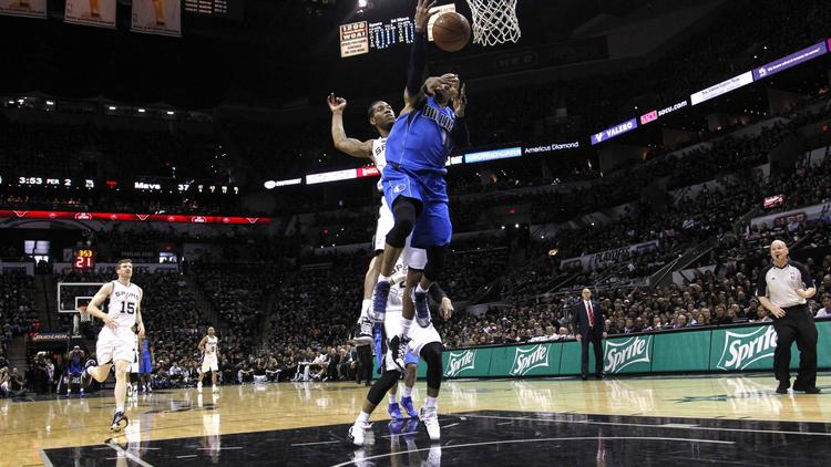 Duel sous le panier entre l'arrière Monta Ellis (N.11) de Dallas Mavericks et l'ailier des Spurs Kawhi Leonard (N.2) dans le match 1 du premier tour des play-offs NBA, dans la salle des Spurs le 20 avril 2014 [Chris Covatta / AFP]