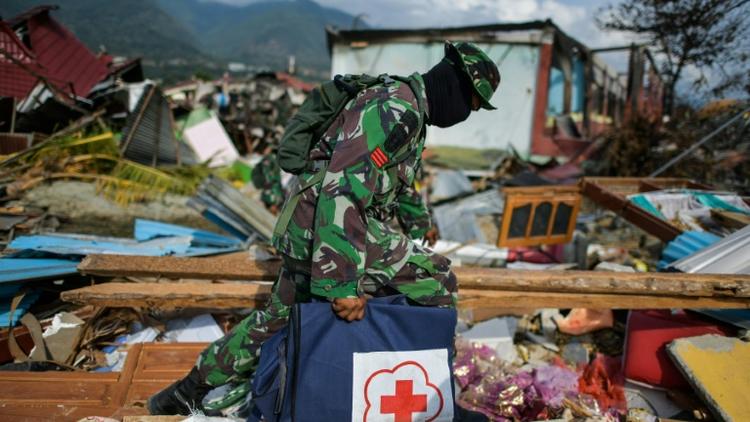 Un soldat indonésien marche dans les décombres dans le quartier de Perumnas Balaroa à Palu, après un séisme suivi d'un tremblement de terre, dans l'île des Célèbes en Indonésie le 6 octobre 2018 [MOHD RASFAN / AFP]