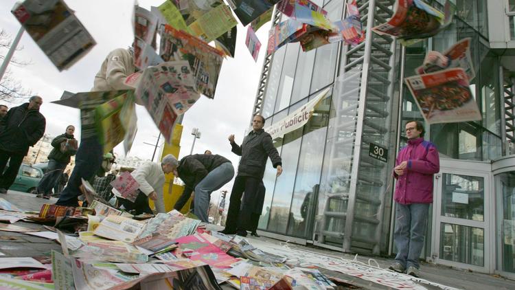 L'organisation Résistance à l'agression publicitaire (RAP) déverse des prospectus, le 09 décembre 2006 devant un centre commercial à Paris, lors d'une action de résistance à l'agression publicitaire pour protester contre les publicités distribuées dans les boîtes aux lettres [Jack Guez / AFP/Archives]