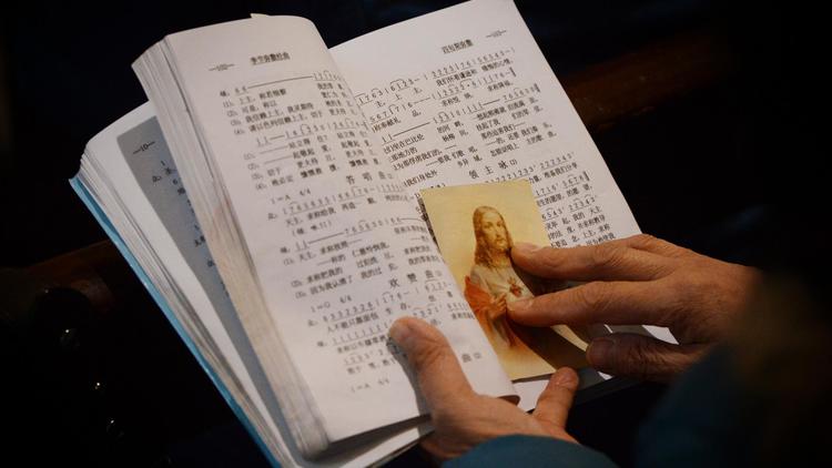 Photo du 12 février 2013 à la cathédrale de Shanghai montrant un missel et une image pieuse: la communauté catholique chinoise serait forte de 12 millions de fidèles dont la moitié sous contrôle officiel et l'autre loyale au Vatican 
 [Mark Ralston / AFP/Archives]
