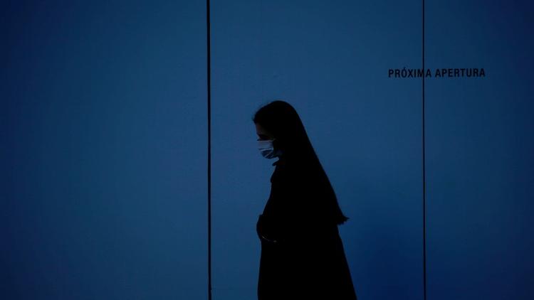 Une femme portant un masque de protection, le 21 mars 2020 à Madrid [Pau Barrena / AFP]