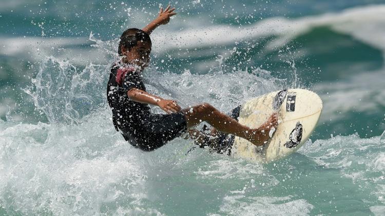 Rickson Falcao, 10 ans, surfe sur une vague au large de Saquarema, dans l'Etat de Rio, au Brésil, le 29 novembre 2017 [LEO CORREA / AFP]