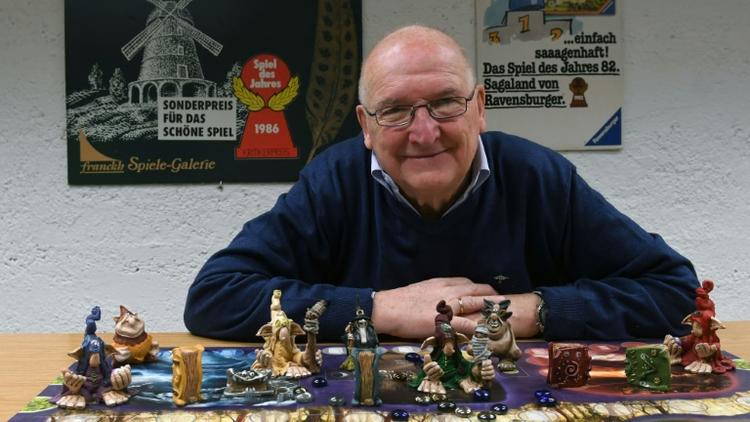 Tom Werneck, collectionneur de 79 ans, pose derrière un jeu de plateau aux archives Bayerisches Spielearchiv des jeux de société, à Munich, dans le sud de l'Allemagne, le 12 décembre 2018  [Christof STACHE / AFP]