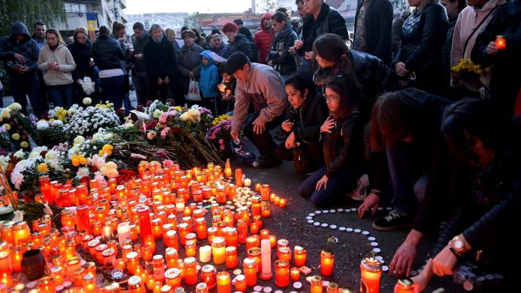 Des personnes disposent des bougies en hommage aux victimes de l'incendie dans la discothèque à Bucarest,  le 31 octobre 2015 [DANIEL MIHAILESCU / AFP]