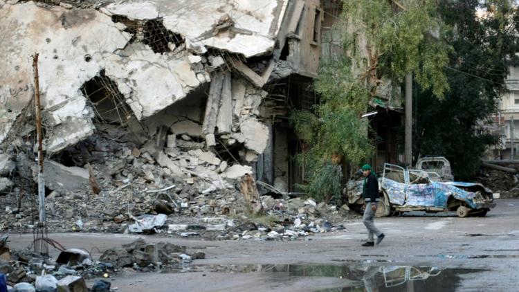 Un homme dans une rue dévastée de la ville syrienne de Deir Ezzor (est), le 15 février 2014 [Ahmad Aboud / AHMAD ABOUD/AFP/Archives]