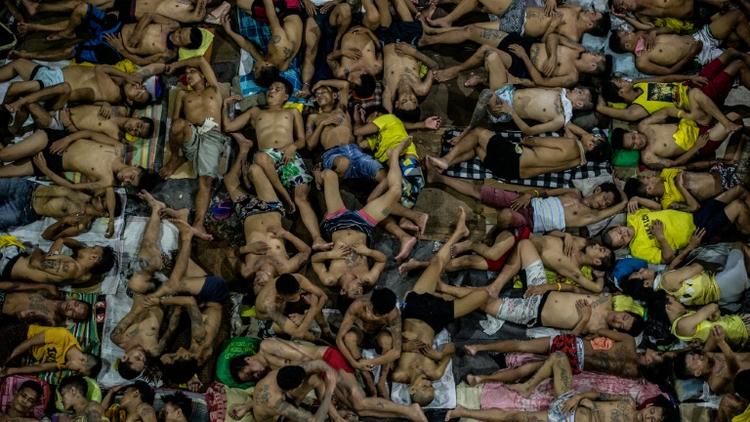 Des détenus dorment les uns sur les autres sur le terrain de basket de la prison surpeuplée de Quezon City, à Manille, le 19 juillet 2016 [NOEL CELIS / AFP]