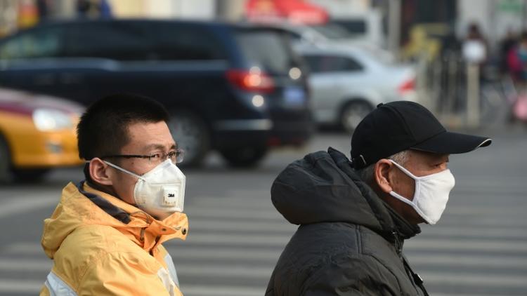 Deux Chinois portent des masques anti-pollution à Pékin le 19 décembre 2015 [GREG BAKER / AFP]