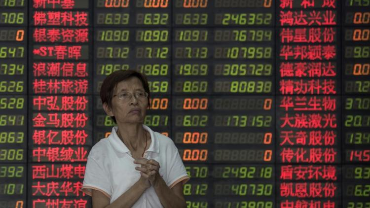 Un investisseur près d'un tableau électronique de cotations dans une société de Bourse de Shanghai le 1er septembre 2015 [JOHANNES EISELE / AFP]