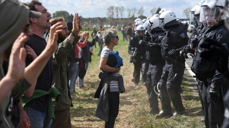 Des militants écologistes font face aux policiers dans la forêt de Hambach à Kerpen, en Allemagne le 15 septembre 2018. [Henning Kaiser / dpa/AFP]