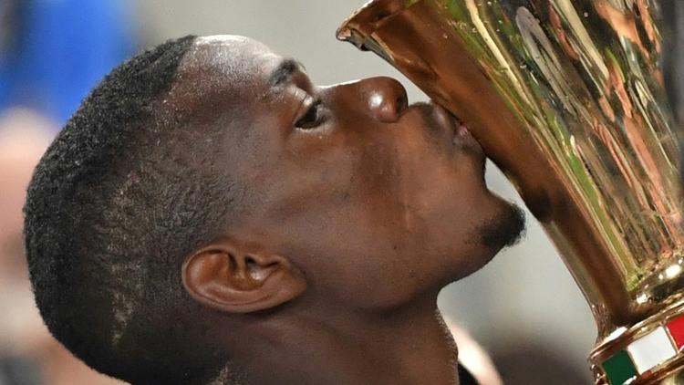 Paul Pogba embrasse le trophée de la Coupe d'Italie remportée avec la Juventus face à l'AC Milan, le 21 mai 2016 à Rome [TIZIANA FABI / AFP/Archives]