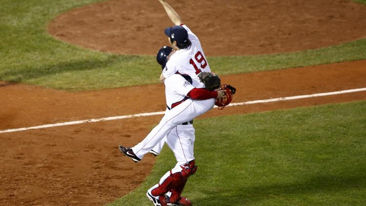 Koji Uehara (N.19) saute dans les bras de David Ross après la victoire de leur équipe, Boston, dans les World Series, finale de la Ligue nord-américaine de baseball (MLB)  [Jared Wickerham / AFP]