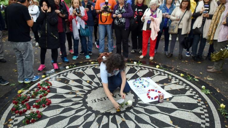 Des fans de John Lennon réunis le 9 octobre 2015 à New York, au mémorial Strawberry Field, en bordure de Central Park, dédié au musicien assassiné en 1980 [TIMOTHY A. CLARY / AFP]