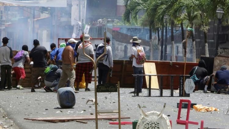 Des manifestants s'abritent derrière des barricades de fortune lors de heurts avec les forces de police, le 2 juin 2018 à Monimbo, près de Masaya, à 40 km de Managua, au Nicaragua [INTI OCON / AFP]