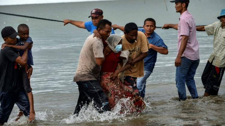 Des pêcheurs du village de Lancok, dans la région d'Aceh, en Indonésie, aident des Rohingyas arrivés par bateau, le 25 juin 2020 [CHAIDEER MAHYUDDIN / AFP]
