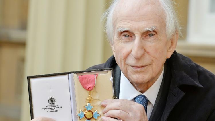 L'auteur britannique Michael Bond, qui a écrit la série de livres de Paddington Bear, pose avec sa médaille d'Officier de l'Ordre de l'Empire britannique au palais de Buckingham à Londres, le 27 octobre 2015 [JOHN STILLWELL / POOL/AFP]