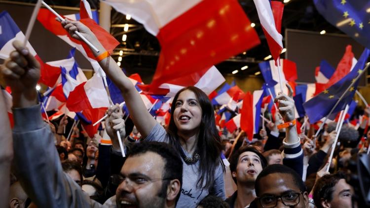 Joie de militants d'Emmanuel Macron après l'annonce de sa qualification pour le second tour de la présidentielle, le 23 avril 2017 à Paris [Patrick KOVARIK / AFP]