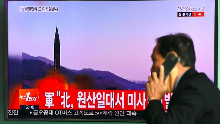 Un homme passe devant un écran de télévision montrant un tir de missile nord Coréen le 22 mars 2017 à Séoul [JUNG Yeon-Je / AFP/Archives]
