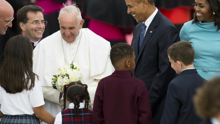 Le pape François, entouré de Barack et Michelle Obama, reçoit des fleurs à son arrivé à Andrews Air Force Base dans le Maryland aux Etats-Unis le 22 septembre 2015 [SAUL LOEB / AFP]