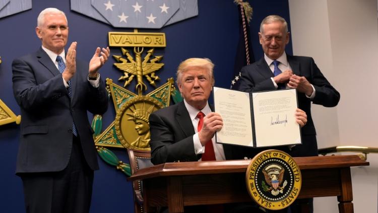 Le président américain Donald Trump signe un décret lors de la cérémonie d'investiture du secrétaire américain à la Défense James Mattis (d) en présence du vice-président Mike Pence (g), le 27 janvier 2017 au Pentagone, à Washington [MANDEL NGAN / AFP]