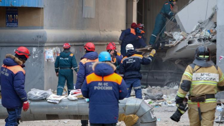 Des sauveteurs travaillent le 2 janvier 2019 sur le site d'un immeuble ravagé deux jours auparavant par une explosion de gaz à Magnitogorsk dans l'Oural russe [STR / AFP]