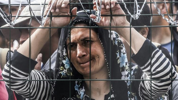 Une femme bloquée derrière la clôture de barbelés le 16 septembre 2015 à Horgos à la frontière entre la Hongrie et la Serbie  [ARMEND NIMANI / AFP]