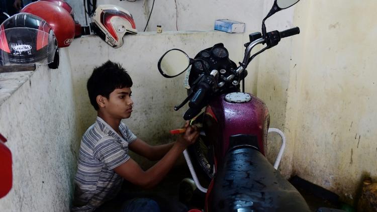 Russel, 13 ans, travaille dans un garage à Dacca, au Bangladesh, le 7 décembre 2016 [MUNIR UZ ZAMAN / AFP]