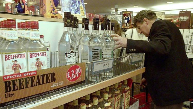 Un Britannique achète une bouteille d'alcool hors-taxes à bord d'un ferry entre Calais et Douvres le 30 juin 1999, au dernier jour avant la disparition des duty free au sein de l'Union européenne  [DENIS CHARLET / AFP]