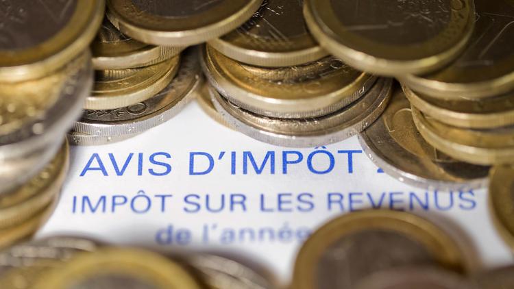 Photo d'un avis d'imposition sur le revenu et de pièces [Joël Saget / AFP/Archives]