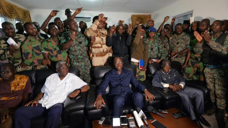 Une délégation de soldats rebelles se tiennent derrière le ministre ivoirien de la Défense Alain Richard Donwahi (C) après des négociations, le 7 janvier 2017 à Bouaké   [SIA KAMBOU / AFP]