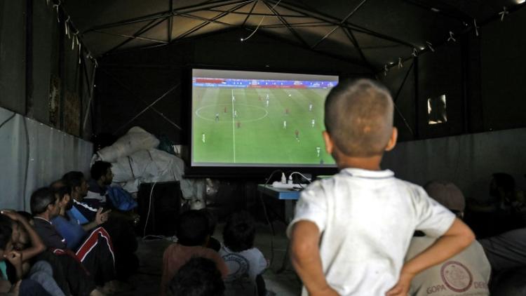 Des déplacés syriens regardent une rencontre du Mondial-2018 de football, le 17 juin dans la province de Raqa [Delil SOULEIMAN / AFP]