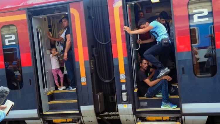 Des migrants montent dans un train en direction de l'Autriche et l'Allemagne, dans la gare de Budapest le 31 août 2015 [ATTILA KISBENEDEK / AFP/Archives]