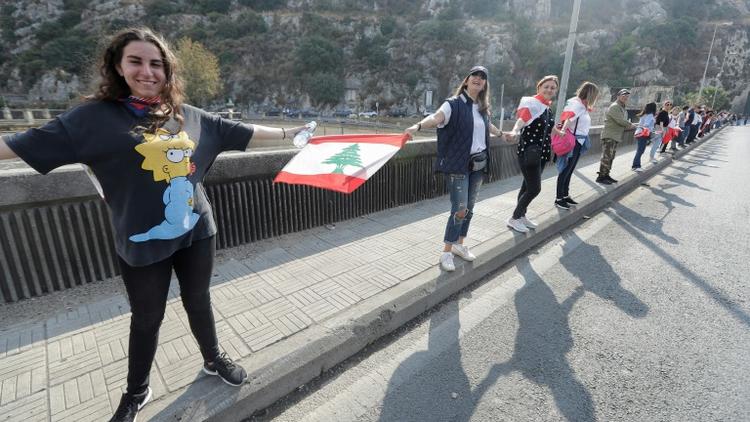 Une chaîne humaine est formée par des manifestants, ici à Nahr al-Kalb dans le nord de Beyrouth, au Liban [JOSEPH EID / AFP]