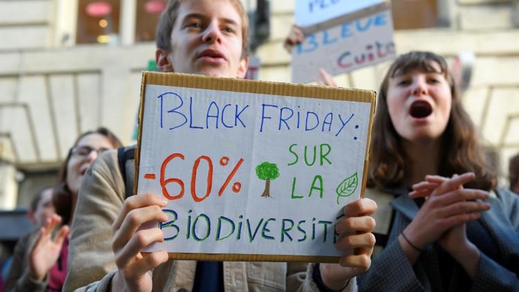 A Bordeaux, manifestation contre la surconsommation où des jeunes brandissent une banderole: "Black friday: 60% de réduction sur la biodiversité", le 29 novembre 2019 [NICOLAS TUCAT / AFP]