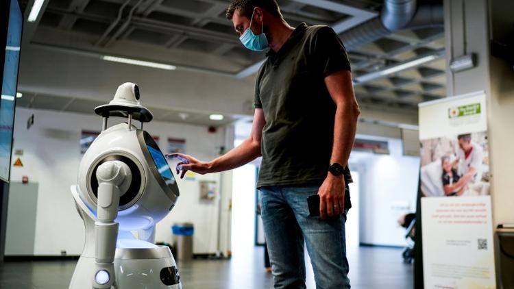 Un employé de la compagnie ZoraBots teste un robot appelé CRUZR le 29 mai 2020 à l'hôpital d'Anvers [Kenzo TRIBOUILLARD / AFP]