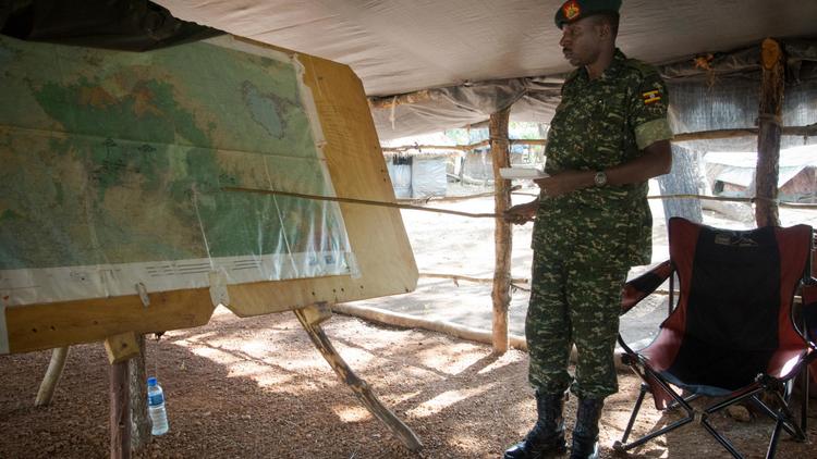 Un soldat de l'UPDF, l'armée ougandaise engagée dans la lutte contre la guerilla de la LRA, montre une carte à la base militaire de Kocho en Centrafrique, le 24 juin 2014  [Michele Sibiloni / AFP/Archives]