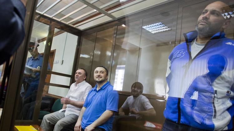 Les suspects du meurtre d'Anna Politkovskaïa (de g à d) Lom-Ali Gaitoukaïev, Roustam Makhmoudov et l'ancien officier de police Sergeï Khadzhikurbanov, lors d'une précédente audience par la justice le 4 juin 2013 à Moscou [Evgeny Feldman / AFP/Archives]