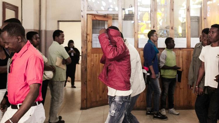 Un accusé cache son visage alors qu'il quitte le tribunal d'Antananarivo, le 9 octobre 2015 [RIJASOLO / AFP]