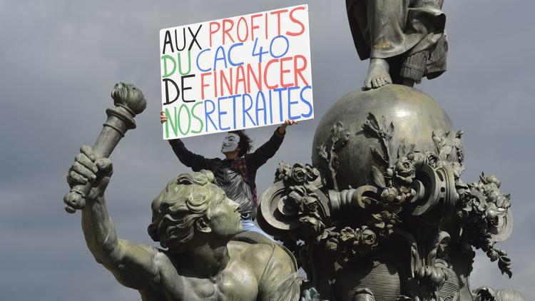 Un manifestant juché sur la statue place de la République participe à un rassemblement pour défendre les retraites, le 10 septembre 2013 à Paris [Eric Feferberg / AFP/Archives]