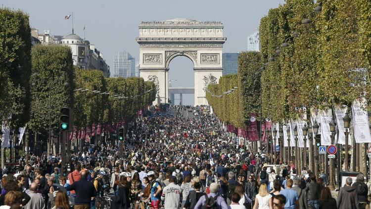 Des promeneurs et des cyclistes sur les Champs-Elysées pour la première "journée sans voiture" à Paris le 27 septembre 2015 [THOMAS SAMSON / AFP]