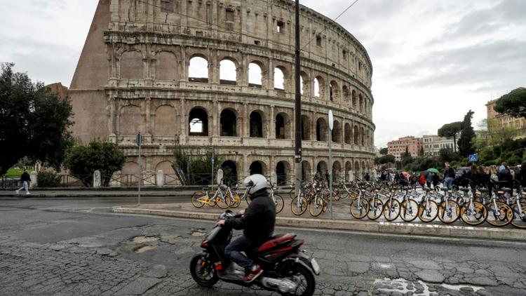 Un motocylciste roule près du Colisée à Rome, le 12 avril 2018  [Andreas SOLARO / AFP]