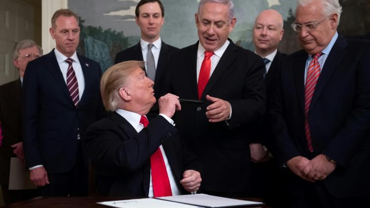 Donald Trump tend son stylo au Premier ministre israélien Benjamin Netanyahu après avoir signé le décret reconnaissant officiellement la souveraineté d'Israël sur le plateau du Golan, le 25 mars 2019 à Washington [SAUL LOEB / AFP]