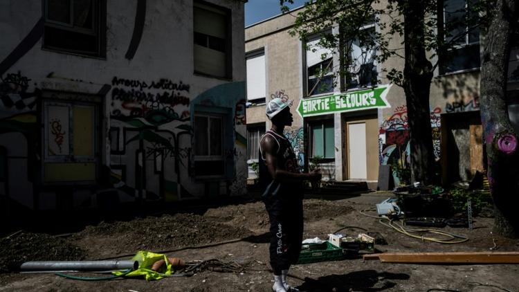 Un homme dans la cour d'une école temporairement reconvertie en centre d'accueil pour migrants, le 16 avril 2020 à Lyon  [JEFF PACHOUD / AFP/Archives]