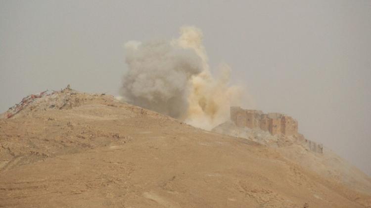 De la fumée s'élève au-dessus de la citadelle de Palmyre, en Syrie, le 25 mars 2016 [ / AFP]