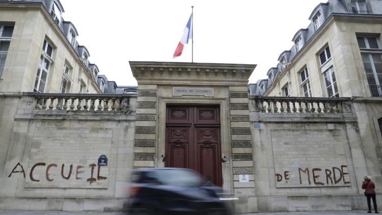 Des militants d'associations de défense des migrants ont tagué "accueil de merde" sur la façade du ministère du Logement à Paris le 16 décembre 2017 pour dénoncer les conditions de réception des migrants en France [Thomas SAMSON / AFP]