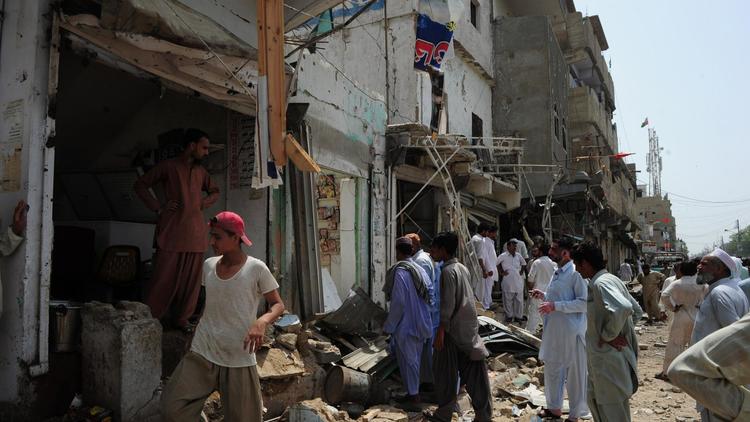 Des Pakistants viennent constater les dégats causés par une explosion, le 11 mai 2013 à Karachi [Asif Hassan / AFP/Archives]