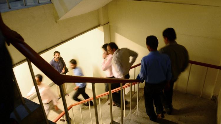 Des employés quittent leur lieu de travail alors que la terre à tremblé à Karachi au Pakistan, le 24 septembre 2013 [Rizwan Tabassum / AFP]