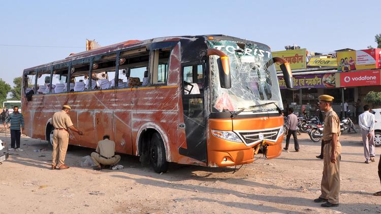 Des policiers indiens inspectent le bus accidenté qui transportait des touristes français en Inde, le 14 octobre 2013 [ / AFP]