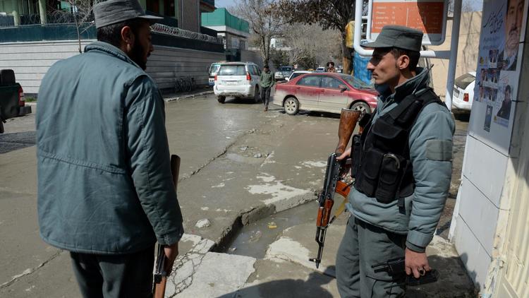 Deux policiers afghans sur le lieu du meurtre d'un journaliste anglo-suédois à Kaboul le 11 mars 2014 [Shah Marai / AFP]