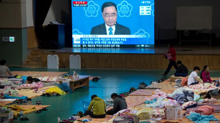 Des familles des victimes du naufrage du ferry Sewol regardent à la télévision le Premier ministre Chung Hong-Won annonçant sa démission le 27 avril 2014 à Jindo [Ed Jones / AFP/Archives]